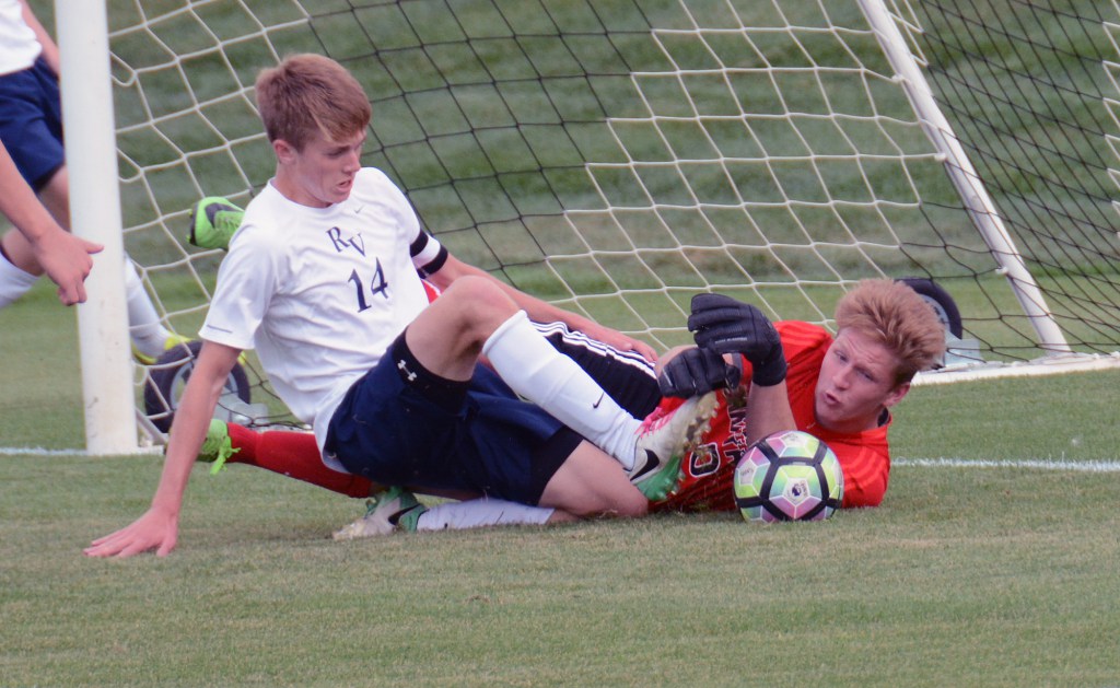 Sam Keller (19) does his best to try and get the ball past Arapahoe keeper Spencer Cobb in the Mustangs season-opening loss to the Warriors.