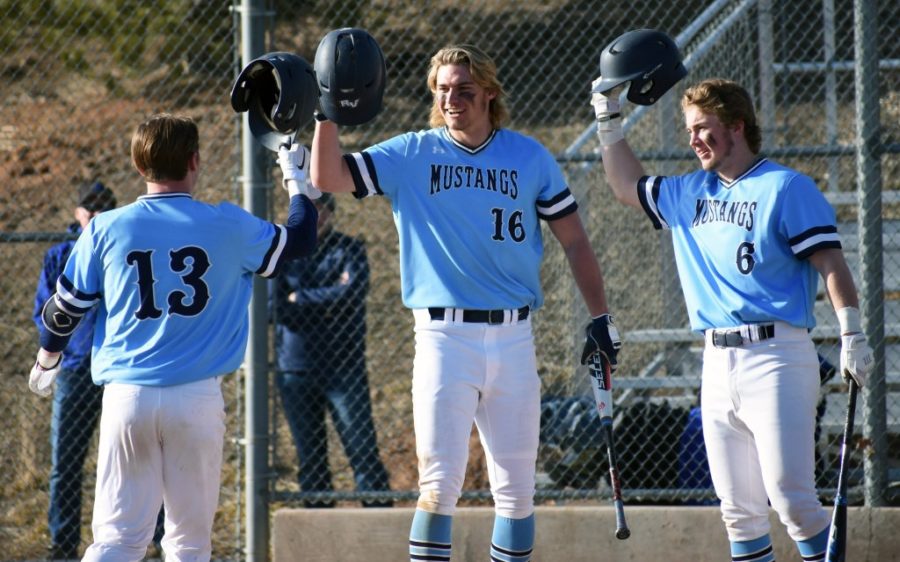 Seniors (from left) Otto Jones, AJ Jergensen, and Trey Adams celebrate a home run for the team.